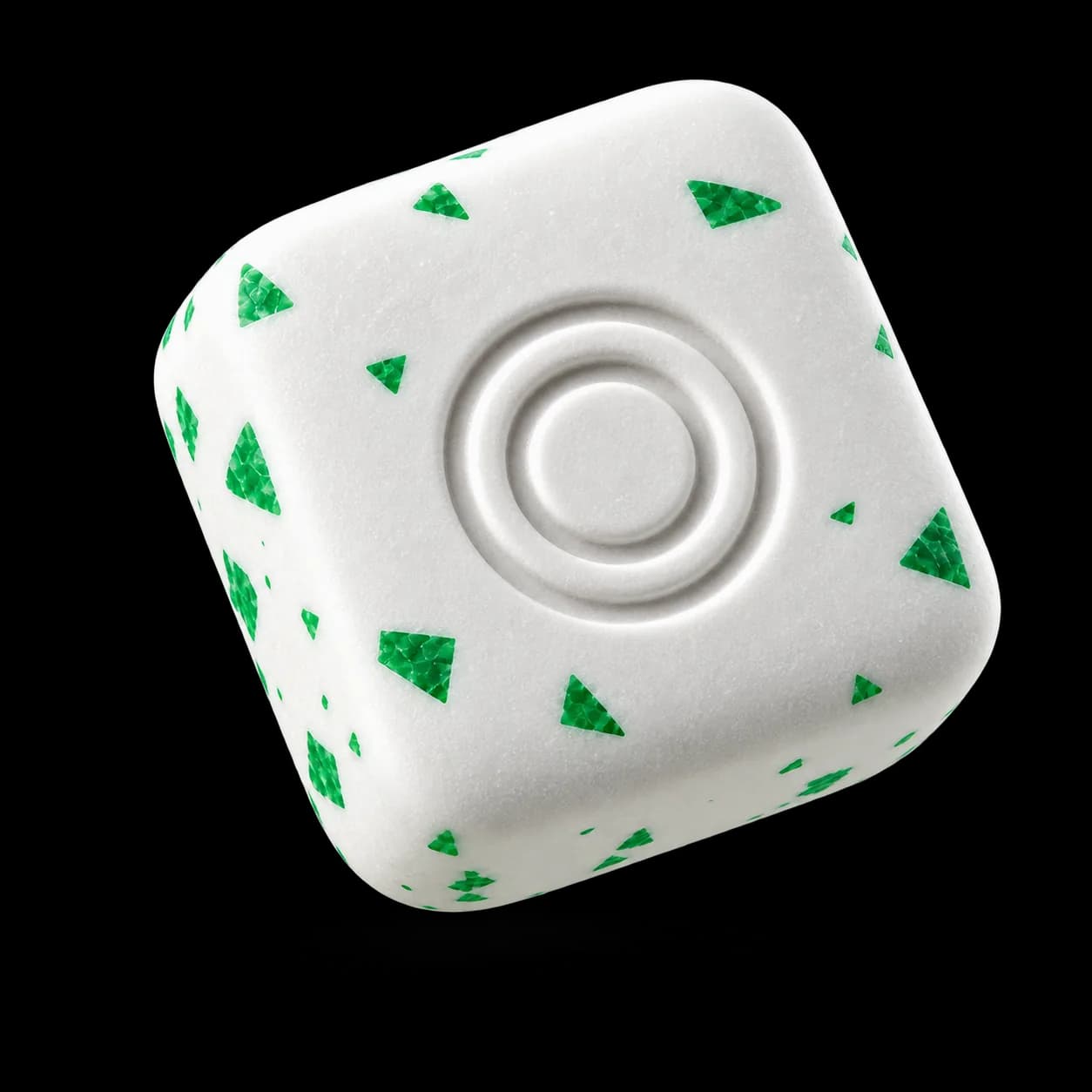 A white energy gum piece with green flecks and an embossed two-ring logo